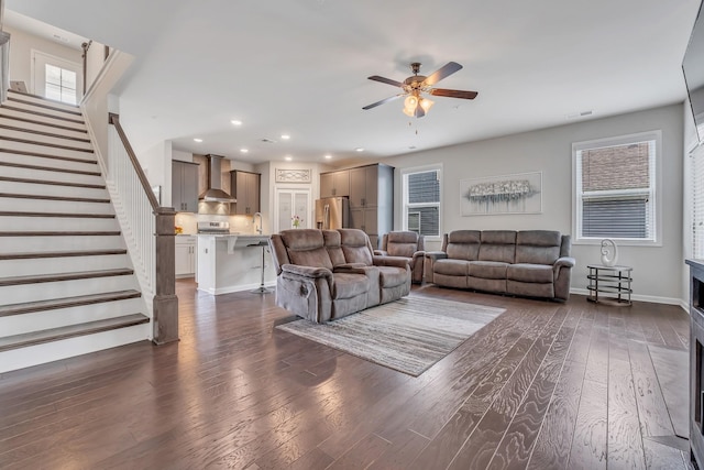 living area featuring visible vents, ceiling fan, stairway, recessed lighting, and dark wood-style floors