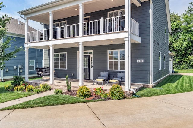 back of house with a balcony and covered porch