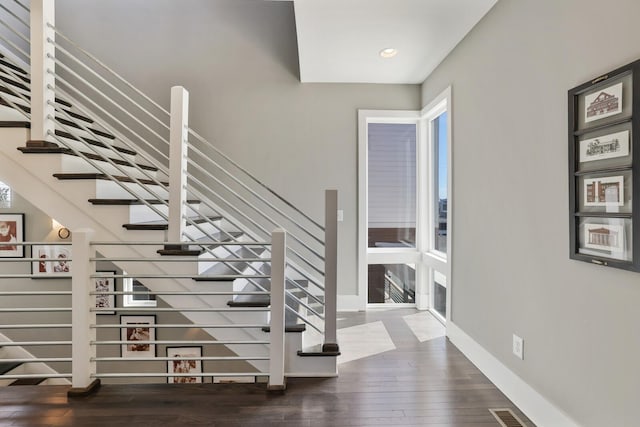 stairway featuring visible vents, plenty of natural light, baseboards, and hardwood / wood-style flooring