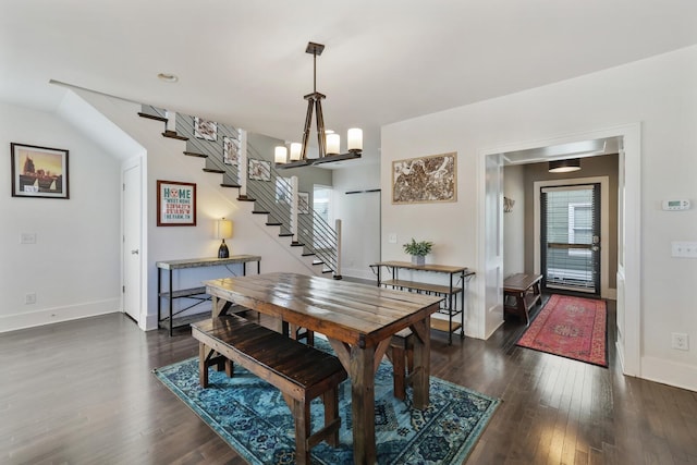 dining space with dark wood-type flooring, stairway, a notable chandelier, and baseboards