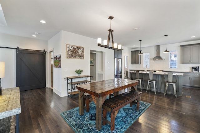 dining area featuring baseboards, visible vents, dark wood finished floors, recessed lighting, and a barn door