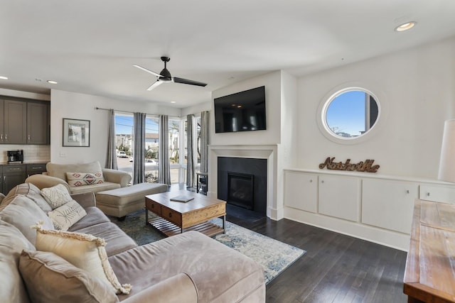 living room featuring recessed lighting, dark wood-style floors, a fireplace with flush hearth, and ceiling fan