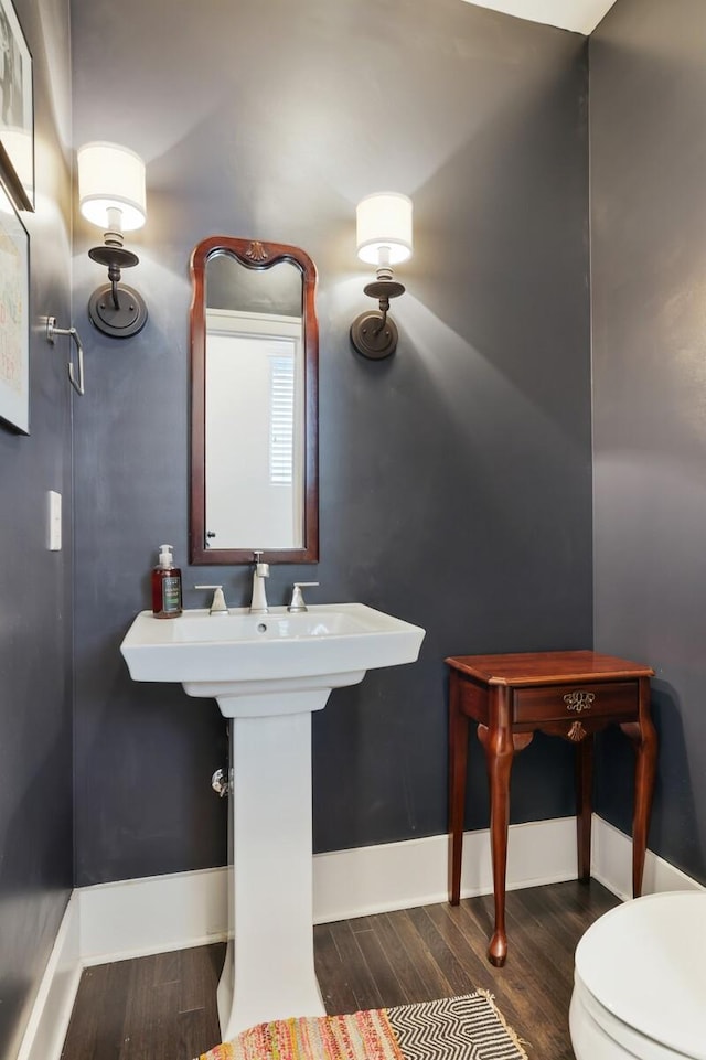 bathroom featuring toilet, baseboards, and wood finished floors