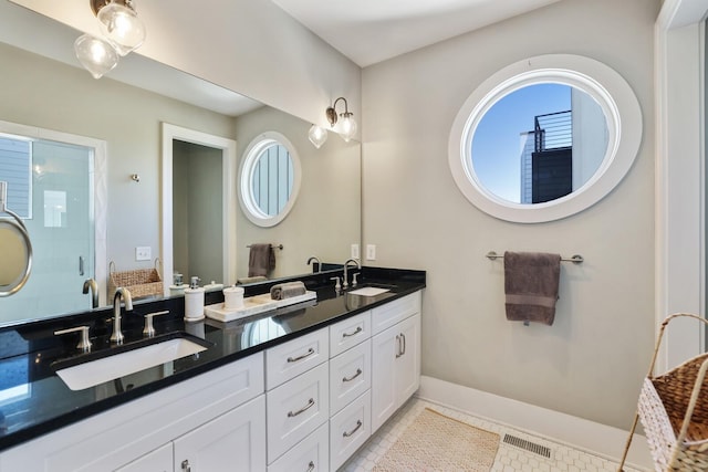 full bathroom with a shower stall, double vanity, visible vents, and a sink