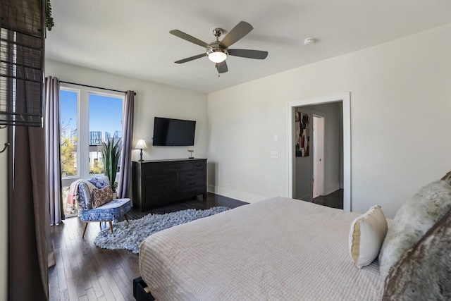 bedroom featuring ceiling fan, dark wood-type flooring, and baseboards