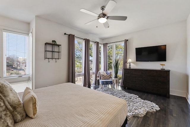 bedroom with dark wood finished floors, multiple windows, a ceiling fan, and baseboards