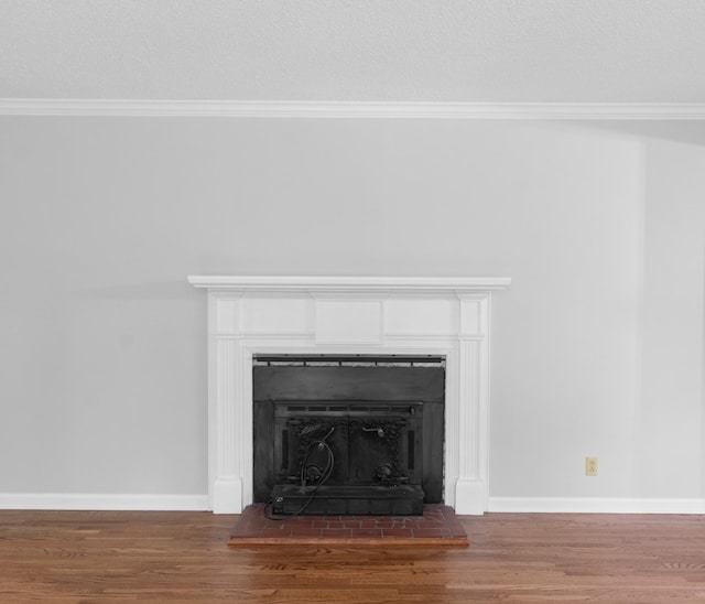 details featuring baseboards, wood finished floors, a fireplace with raised hearth, and crown molding