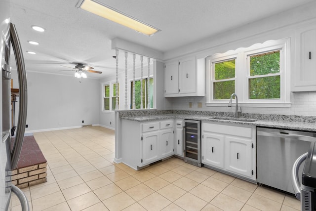 kitchen with a sink, white cabinetry, stainless steel appliances, wine cooler, and a peninsula