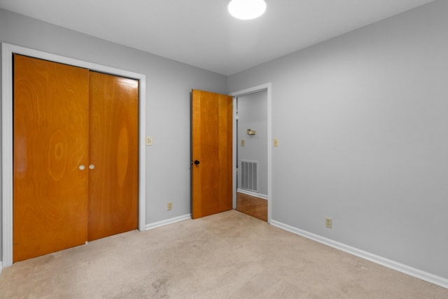 unfurnished bedroom featuring a closet, baseboards, visible vents, and carpet floors