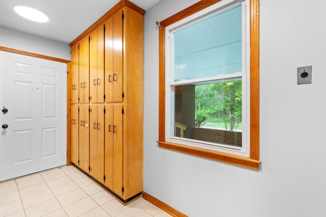 entryway with light tile patterned floors and baseboards