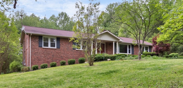 ranch-style home featuring brick siding and a front yard