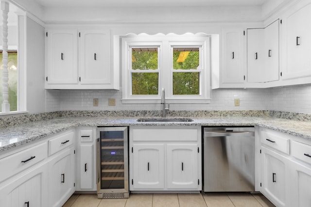 kitchen with beverage cooler, dishwasher, white cabinetry, and a sink