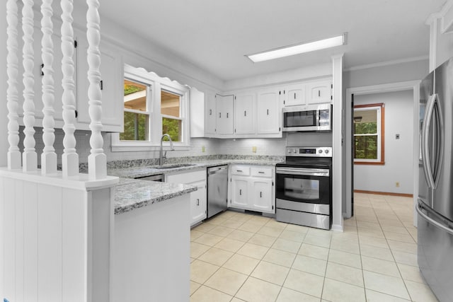 kitchen with tasteful backsplash, appliances with stainless steel finishes, a peninsula, light tile patterned flooring, and a sink