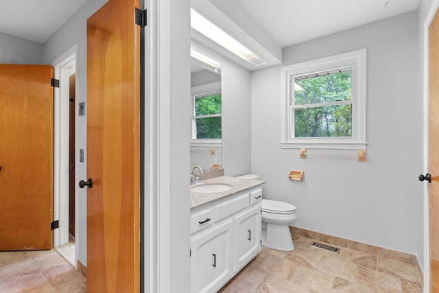 bathroom with visible vents, baseboards, toilet, and vanity