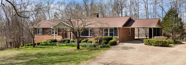 ranch-style house featuring brick siding, an attached carport, concrete driveway, and a front lawn