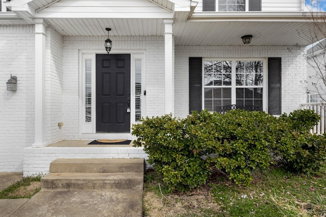 doorway to property featuring brick siding