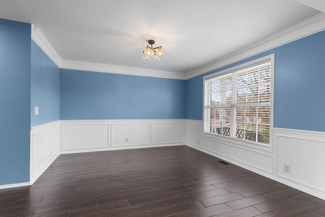 unfurnished room with dark wood finished floors, a wainscoted wall, a notable chandelier, and visible vents