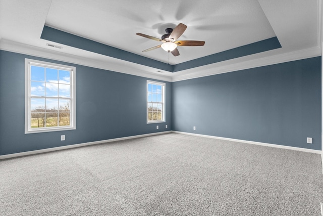 unfurnished room featuring visible vents, a raised ceiling, baseboards, and a ceiling fan