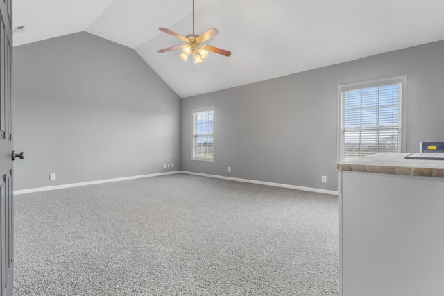 spare room featuring visible vents, baseboards, carpet, vaulted ceiling, and a ceiling fan