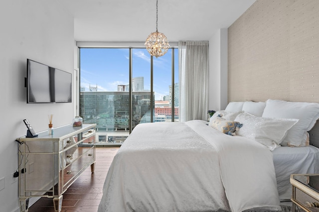 bedroom featuring a notable chandelier, wood finished floors, and expansive windows