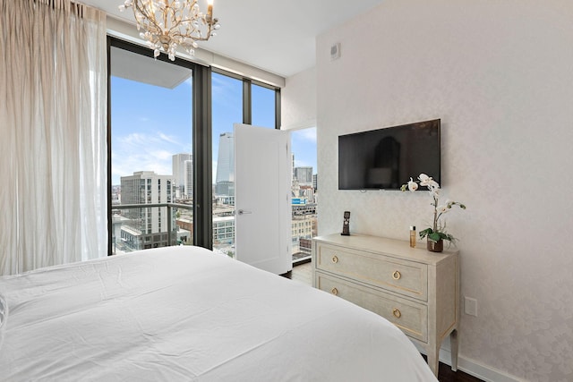 bedroom with a notable chandelier, floor to ceiling windows, baseboards, and wood finished floors