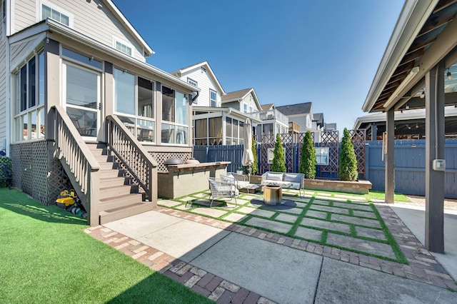 view of patio / terrace with a residential view, an outdoor hangout area, fence, and a sunroom