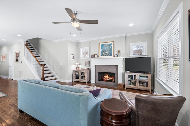 living area with a fireplace with flush hearth, wood finished floors, stairway, crown molding, and baseboards