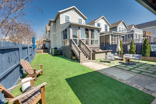 back of property featuring a patio, a fenced backyard, a yard, a residential view, and a sunroom