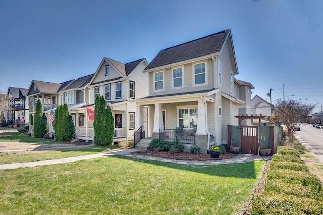 view of front facade featuring a front lawn, a residential view, covered porch, and a pergola