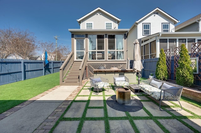 rear view of property with an outdoor living space, a fenced backyard, a yard, a sunroom, and a patio area