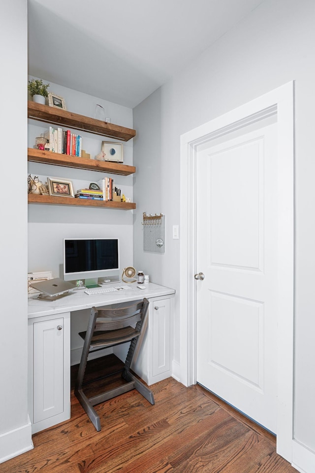 home office featuring built in desk and wood finished floors