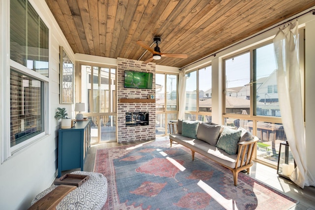 sunroom with wooden ceiling, an outdoor brick fireplace, and ceiling fan