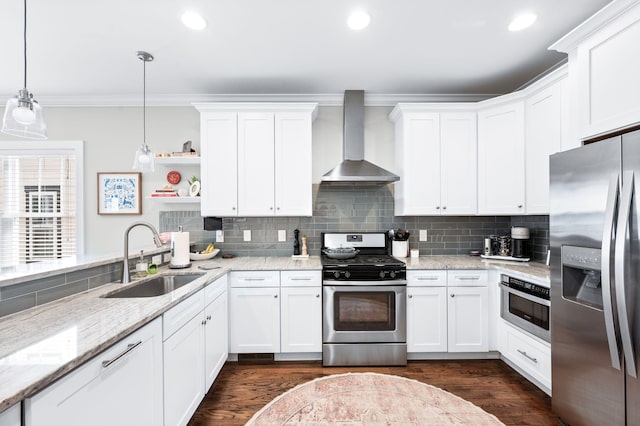 kitchen with ornamental molding, a sink, appliances with stainless steel finishes, wall chimney range hood, and tasteful backsplash