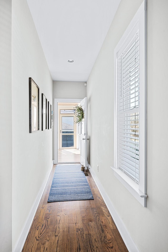 hallway with baseboards and wood finished floors