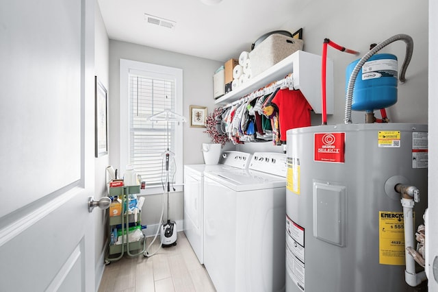 laundry area with visible vents, separate washer and dryer, water heater, and laundry area