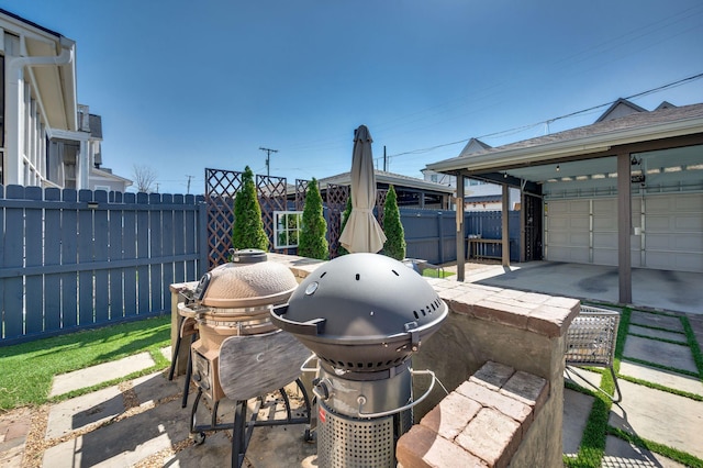 view of patio / terrace with grilling area, a garage, and fence