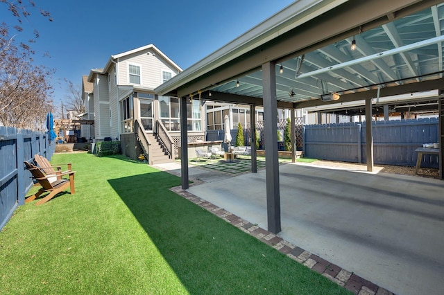 view of yard with a sunroom, a patio, and fence