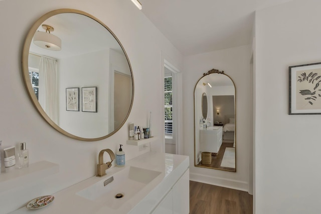 ensuite bathroom with vanity, ensuite bathroom, and wood finished floors