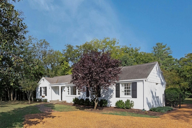 view of front of home featuring a front lawn, fence, and roof with shingles