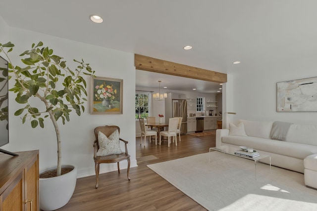 living area with recessed lighting, an inviting chandelier, and wood finished floors