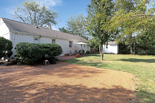 view of yard featuring a patio area and an outdoor structure