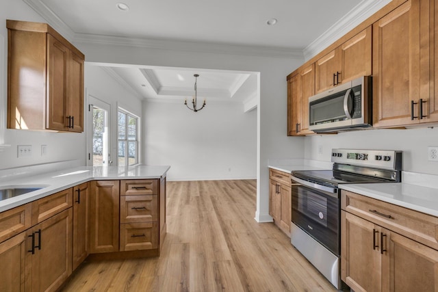 kitchen with brown cabinetry, light wood finished floors, ornamental molding, stainless steel appliances, and light countertops