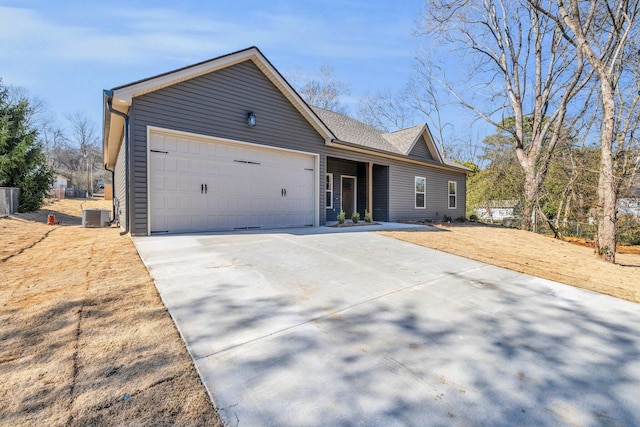 ranch-style house featuring central air condition unit, a garage, and driveway