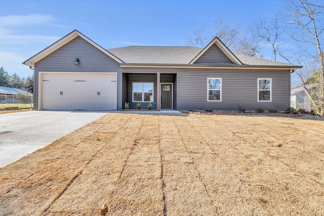 single story home with concrete driveway, a garage, and a shingled roof