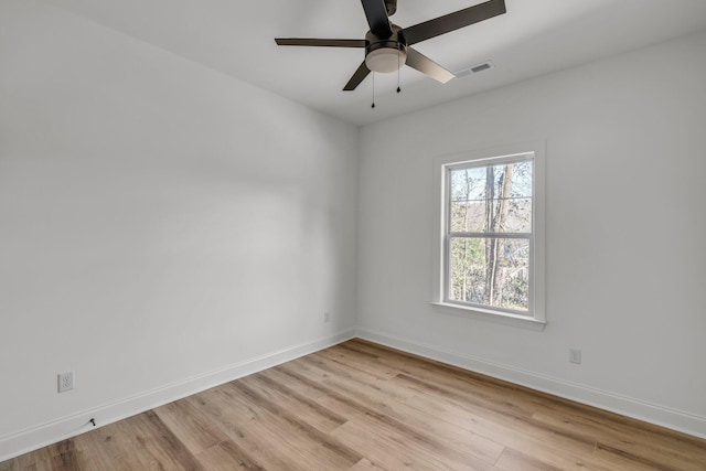 unfurnished room featuring a ceiling fan, light wood-style floors, visible vents, and baseboards