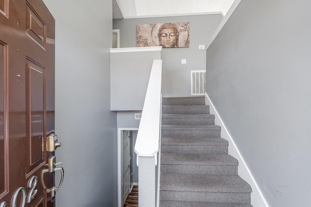 stairway with visible vents and baseboards