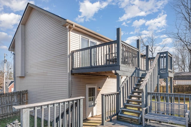 back of property with a deck, stairs, and fence