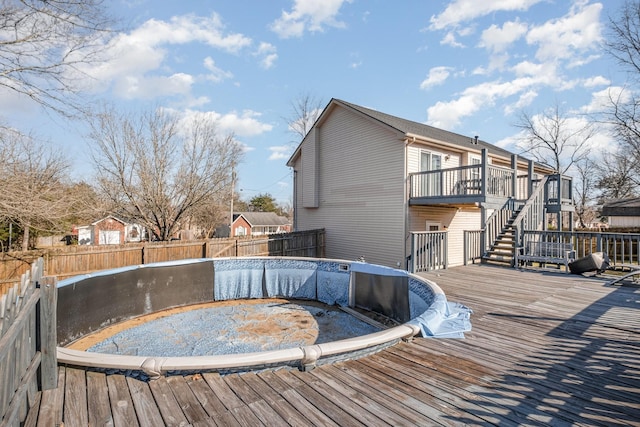 wooden terrace featuring stairs and a fenced backyard