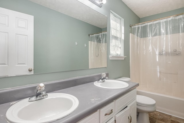 full bath featuring a textured ceiling, double vanity, toilet, and a sink