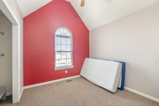 carpeted bedroom featuring lofted ceiling, visible vents, baseboards, and ceiling fan